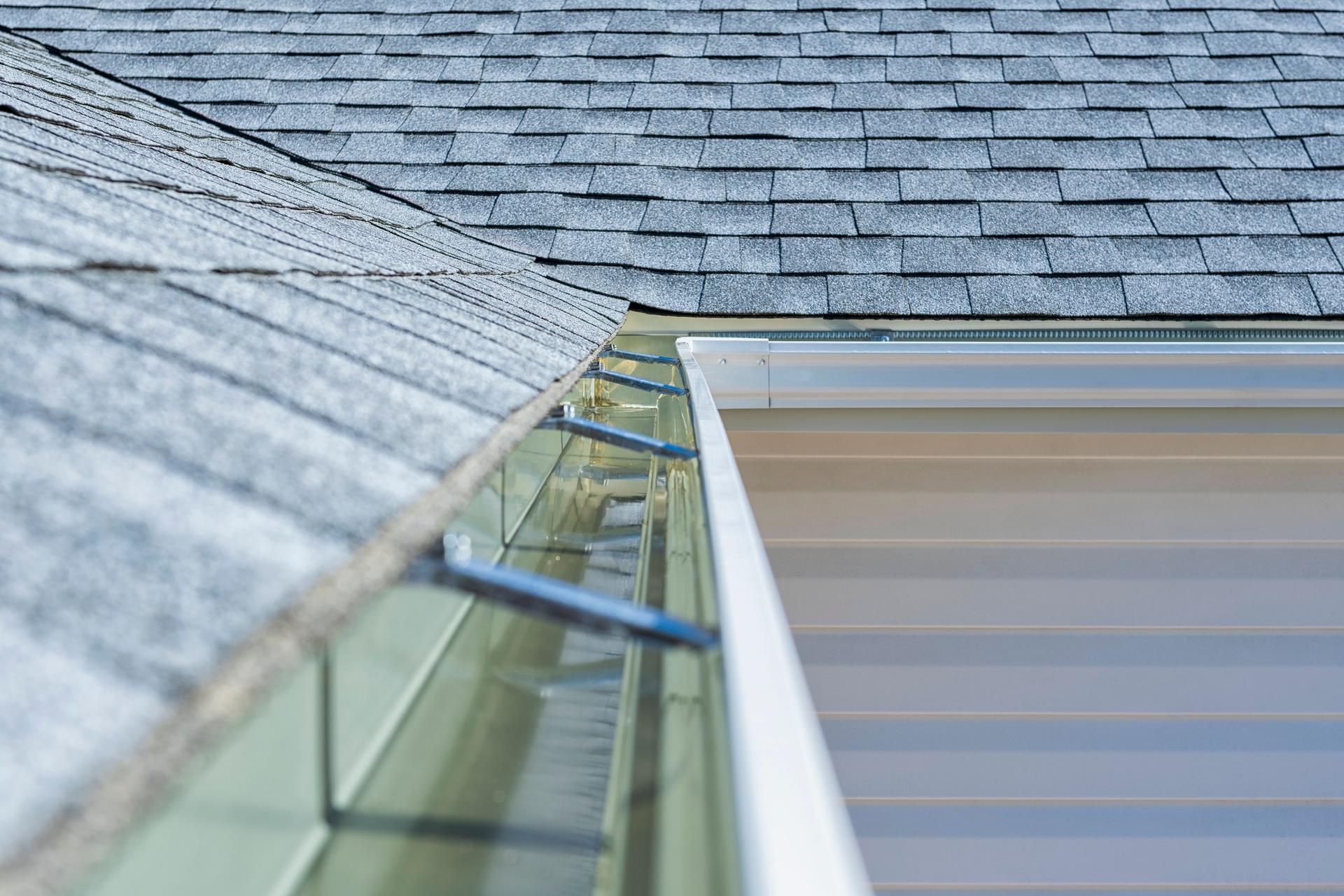 Newly installed rain gutters and asphalt shingles on a residential home